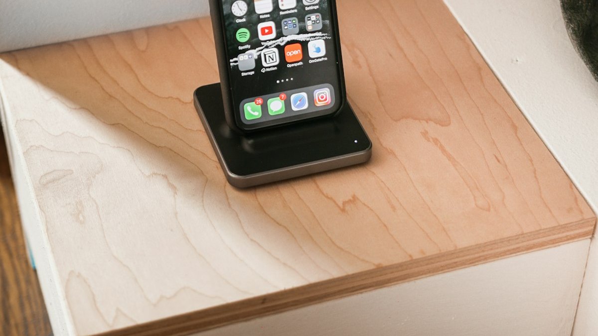 Black iphone 4 on brown wooden table. — a Sleep Finally guide to The Docking Station: One Shelf That Fixes Evenings.
