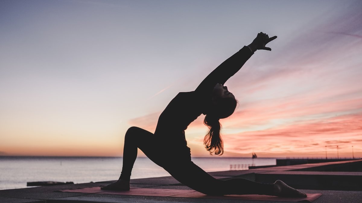 Silhouette photography of woman doing yoga. — a Sleep Finally guide to The Evening Exercise Myth: Where It Came From.