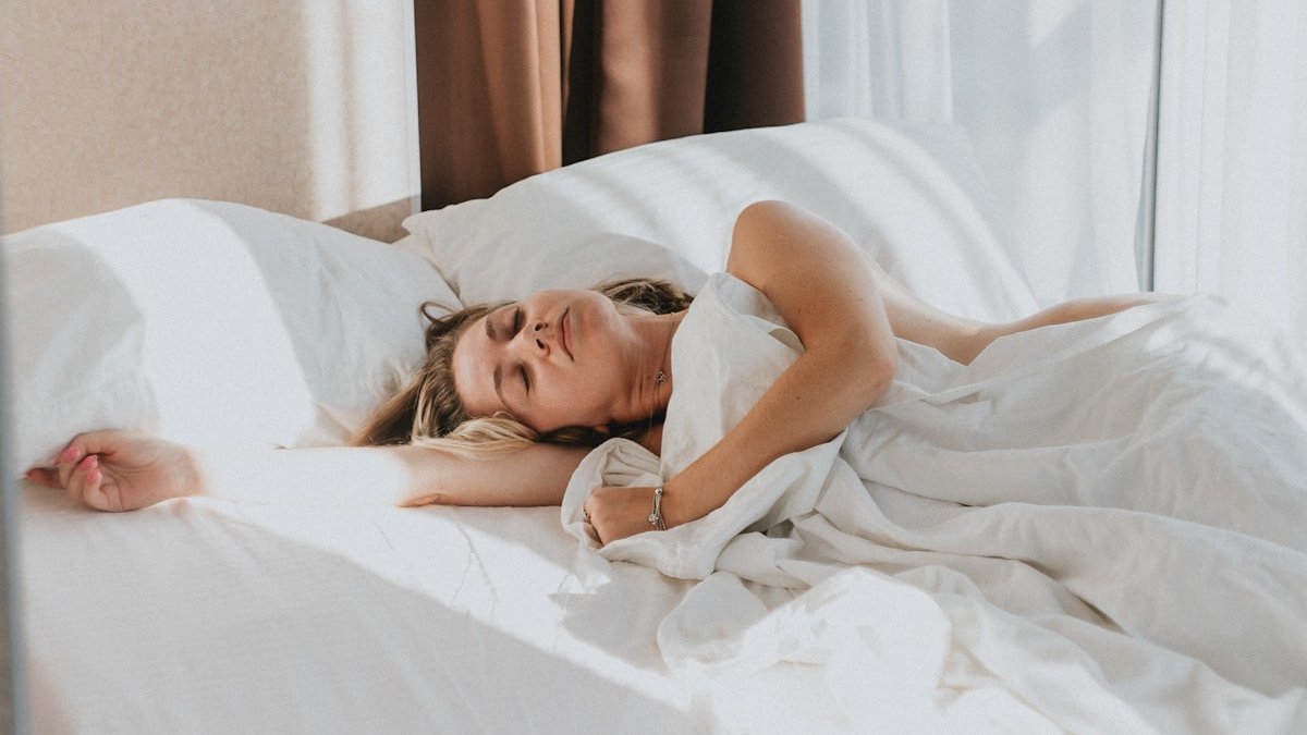 A person lying in a bed. — a Sleep Finally guide to Weekend Sleep Habits That Sabotage Your Monday.