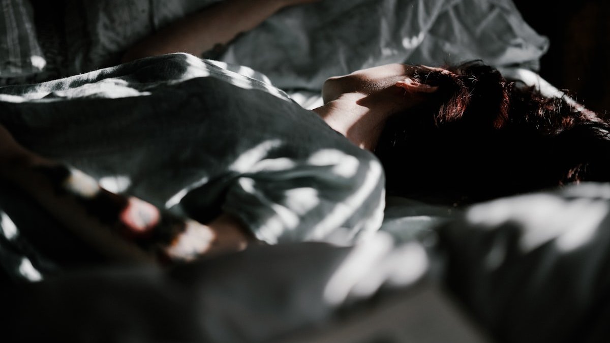A person laying in a bed under a blanket. — a Sleep Finally guide to When a Racing Mind Keeps You Up for Weeks.