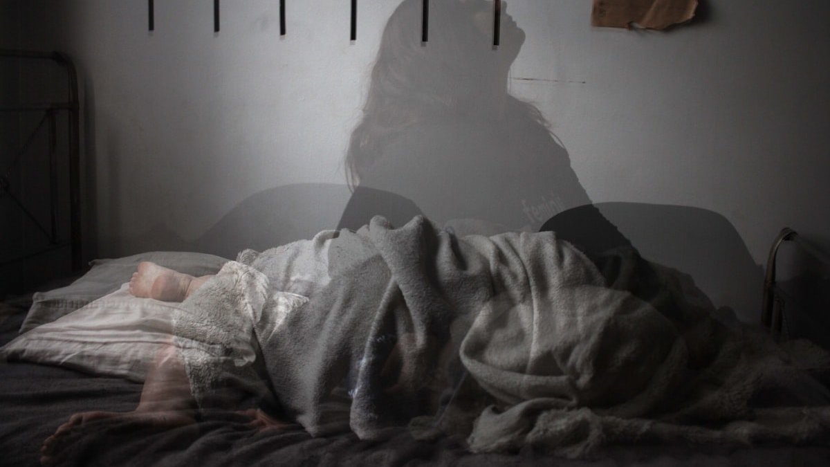 Shadow of woman on bed. — a Sleep Finally guide to Why Anxiety Is Worse at Night (and What to Do).