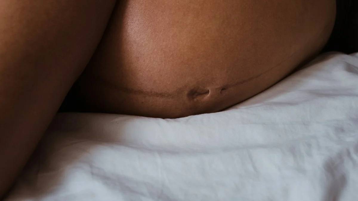 a woman in a black bikini laying on a bed — a Sleep, Finally guide to Why Left Side Sleeping Is Recommended in Pregnancy