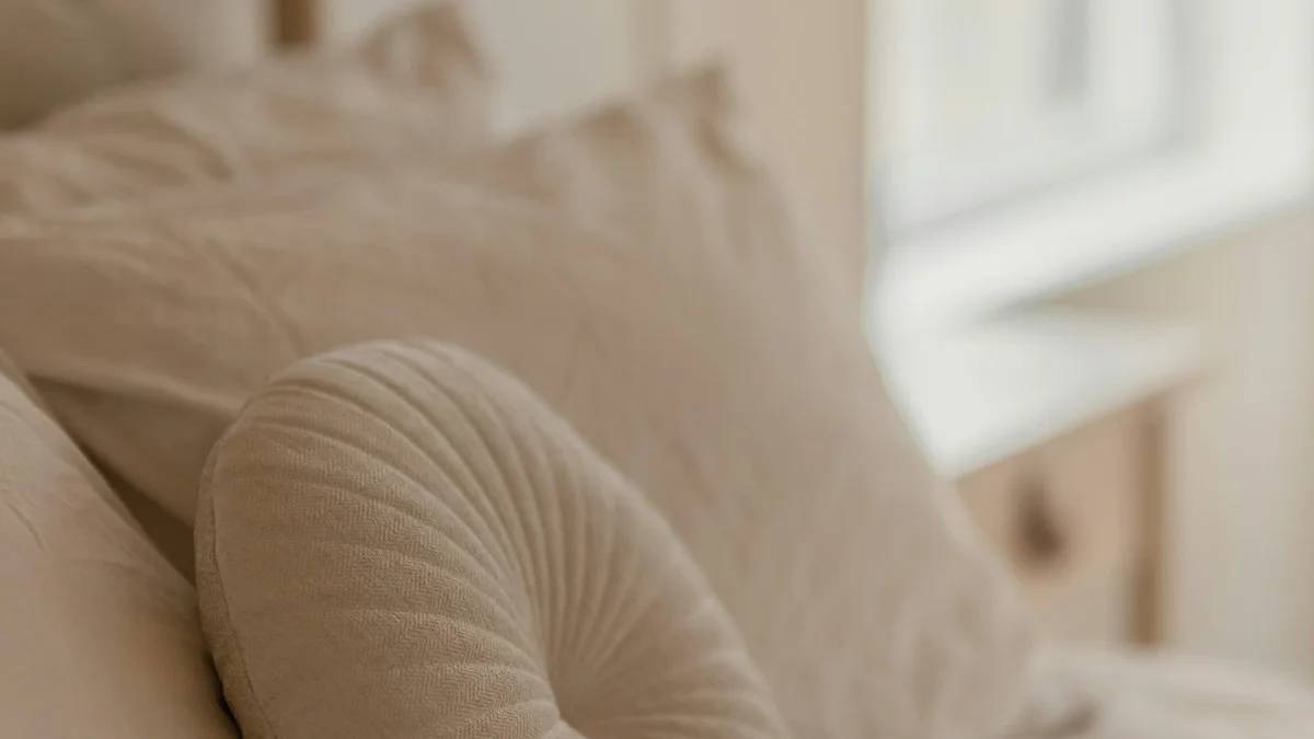 a bed with a white comforter and pillows — a Sleep, Finally guide to Why Progesterone Makes You Sleepy (and When It Backfires)