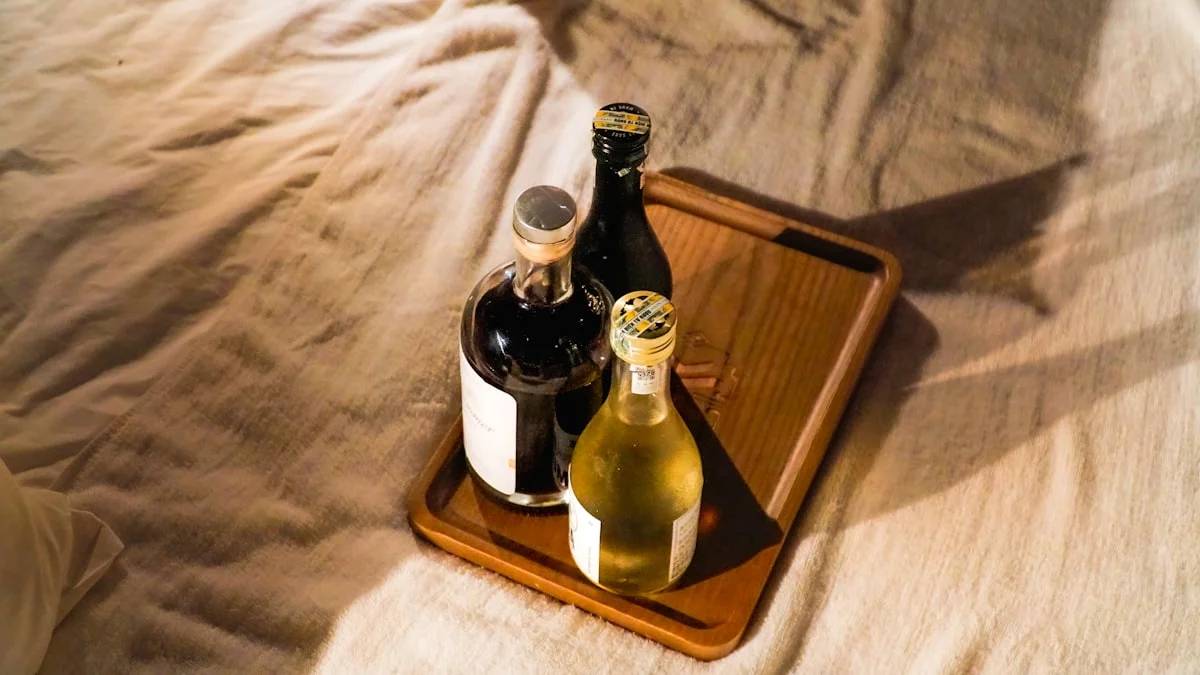 Three bottles on a wooden tray on a rumpled bed — a Sleep, Finally guide to Why the Nightcap Hands You a 3am Wake-Up