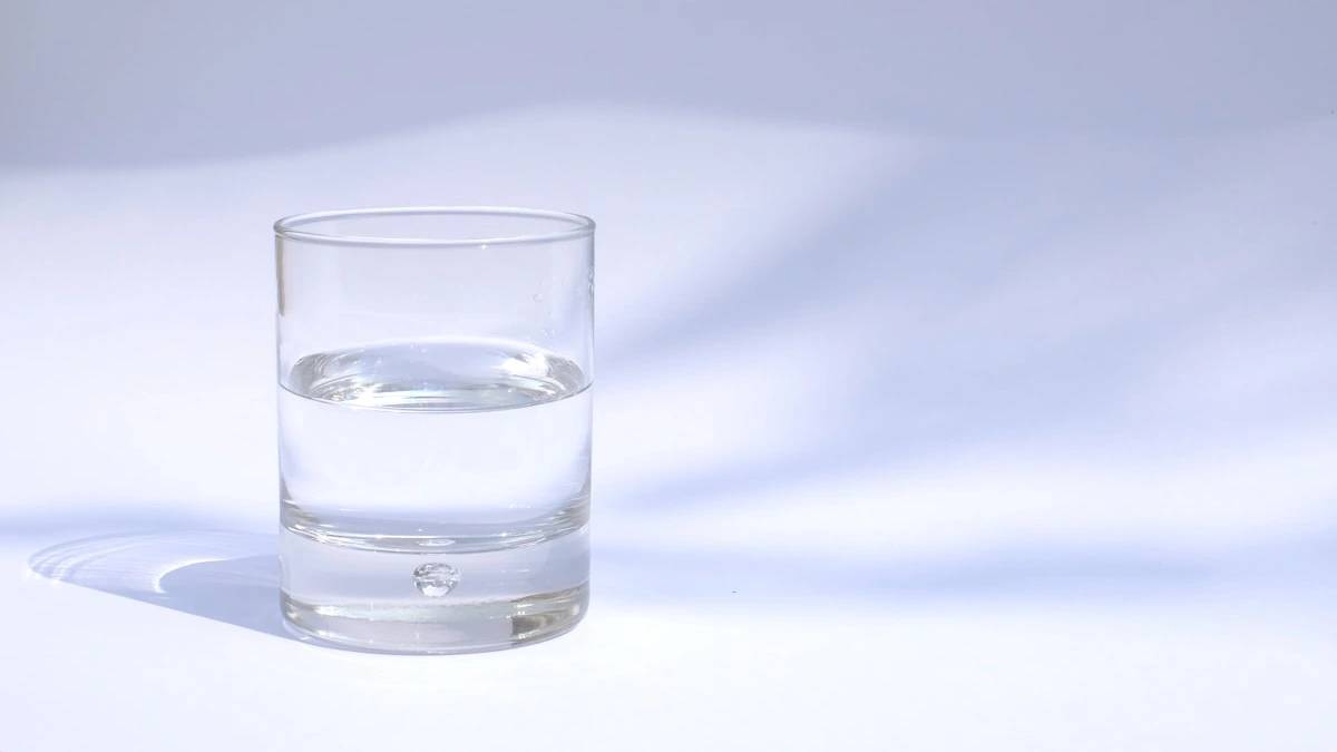 clear drinking glass filled with water — a Sleep, Finally guide to Why You Wake Up Thirsty at 4am After Drinking